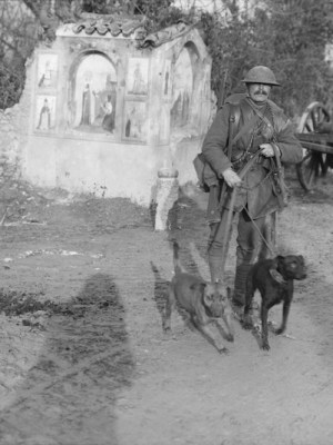 Soldier from the Royal Engineers with two messenger dogs and a roadside shrine (December 1917), Ernest Brooks. Courtesy: Imperial War Museum
