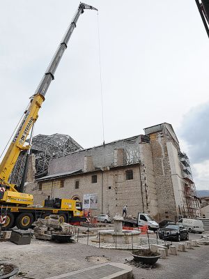 Apeopla pass on 2 April, 2012, by the Santa Maria Paganica church near the 'red zone' closed to public, in the historic area of L'Aquila devastated by the 2009 earthquake. ANDREAS SOLARO/AFP/Getty Images