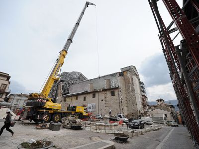 Apeopla pass on 2 April, 2012, by the Santa Maria Paganica church near the 'red zone' closed to public, in the historic area of L'Aquila devastated by the 2009 earthquake. ANDREAS SOLARO/AFP/Getty Images