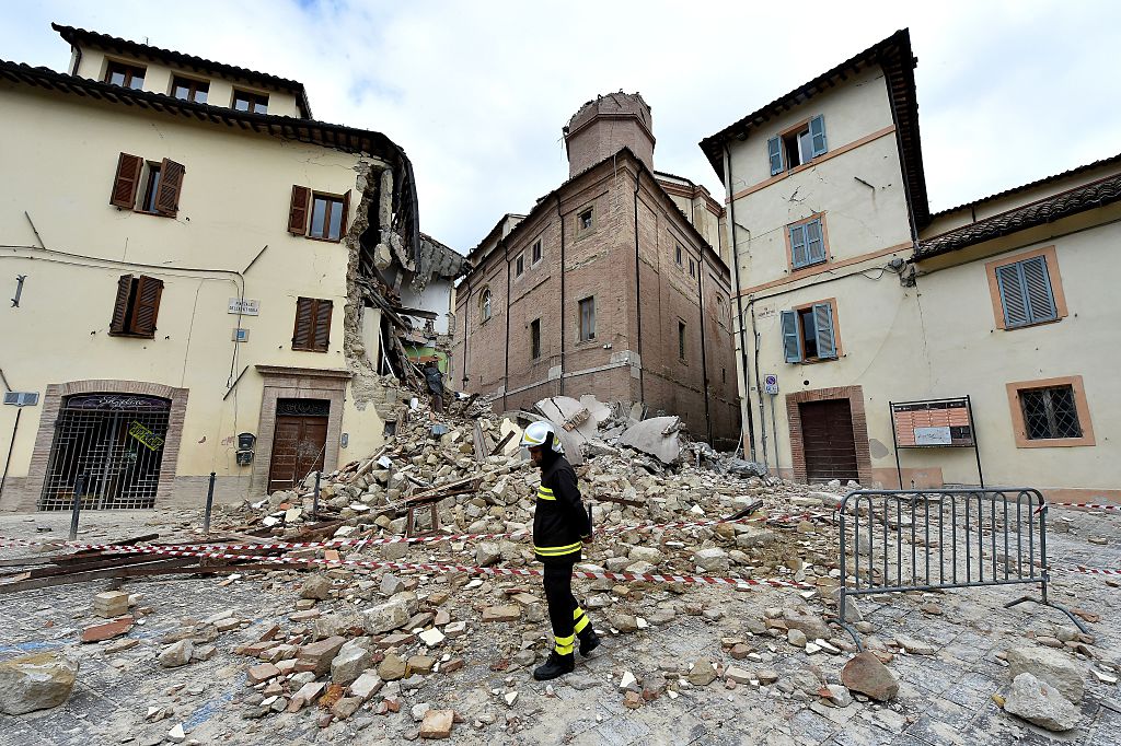 A firefighter stands in front of the collapsed bell tower of the Santa Maria in Via church in the 'red zone', an area cordoned off for safety reasons, in Camerino, where 80 per cent of the houses have been left uninhabitable after two earthquakes hit the region. (28 October, 2016) ALBERTO PIZZOLI/AFP/Getty Images