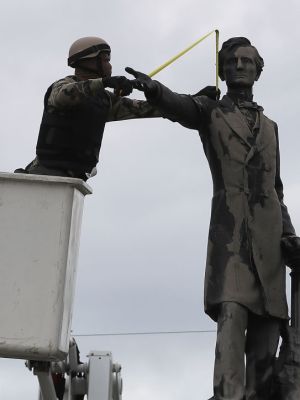 A New Orleans city worker wears body armour and a face covering as he measures the Jefferson Davis monument on 4 May, 2017, in New Orleans, Loiusiana. Photo: Justin Sullivan/Getty Images