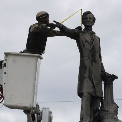 A New Orleans city worker wears body armour and a face covering as he measures the Jefferson Davis monument on 4 May, 2017, in New Orleans, Loiusiana. Photo: Justin Sullivan/Getty Images