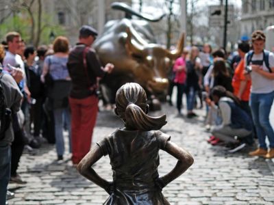 The Fearless Girl (front) statue stands facing the 'Charging Bull' as tourists take pictures in New York on 12 April, 2017. JEWEL SAMAD/AFP/Getty Images