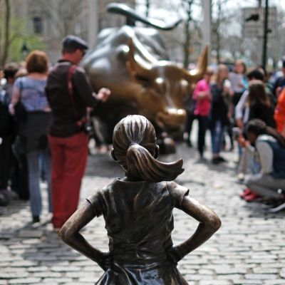 The Fearless Girl (front) statue stands facing the 'Charging Bull' as tourists take pictures in New York on 12 April, 2017. JEWEL SAMAD/AFP/Getty Images