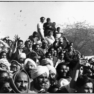 Gandhi's funeral. Crowds gathered between Birla House and the cremation ground, throwing flowers (1948), Henri Cartier-Bresson. © Henri Cartier-Bresson/Magnum Photos