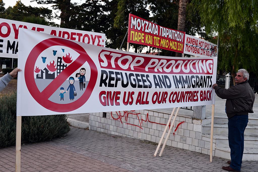 Chios residents arrange banners during an anti-migrant demo on the island of Chios on 28 September, 2016. Irish photographer Richard Mosse claims he was arrested while observing a similar rally on the island last week. Photo: LOUISA GOULIAMAKI/AFP/Getty Images