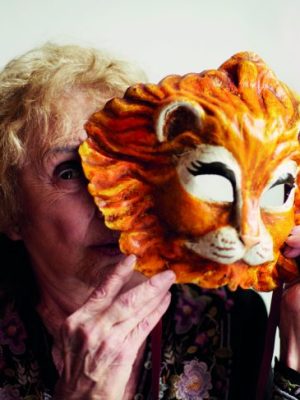 Carolee Schneemann holding a Venetian lion mask, photographed in London in May 2017, Photo: Benjamin McMahon
