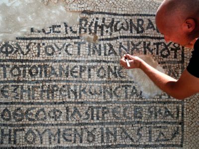 An archaeologist works on part of a 1,500-year-old mosaic discovered near Jerusalem's Damascus Gate, on 23 August 2017. AHMAD GHARABLI/AFP/Getty Images