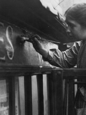 Sylvia Pankhurst painting onto the façade of the Women's Social Defence League shop in Bow Street, London (11 October 1912).