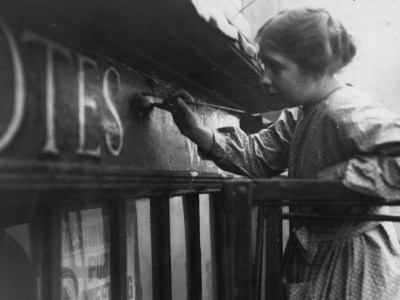 Sylvia Pankhurst painting onto the façade of the Women's Social Defence League shop in Bow Street, London (11 October 1912).