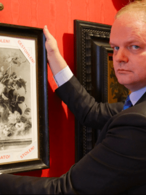 Uffizi director Eike Schmidt with a framed photograph of 'Vase of Flowers' and the word 'stolen' in Italian, English and German. Photo: @UffiziGalleries via Twitter