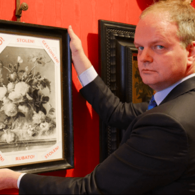 Uffizi director Eike Schmidt with a framed photograph of 'Vase of Flowers' and the word 'stolen' in Italian, English and German. Photo: @UffiziGalleries via Twitter