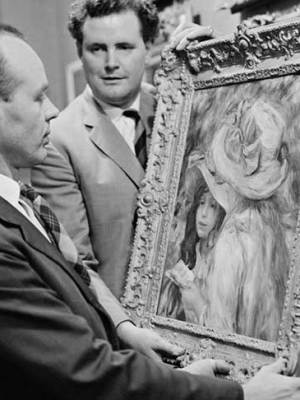 An art adviser, Graham Reid, examines a painting (Les Deux Soeurs) by Pierre-Auguste Renoir before its auction at Sotheby’s in London in 1963.