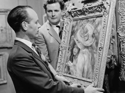 An art adviser, Graham Reid, examines a painting (Les Deux Soeurs) by Pierre-Auguste Renoir before its auction at Sotheby’s in London in 1963.