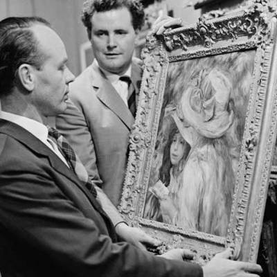 An art adviser, Graham Reid, examines a painting (Les Deux Soeurs) by Pierre-Auguste Renoir before its auction at Sotheby’s in London in 1963.