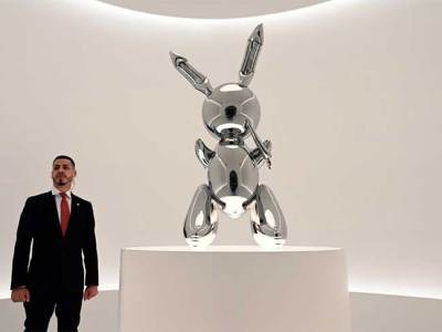 A security guard stands next to Jeff Koons‘ Rabbit (number two from an edition of three, plus one artist’s proof; 1986) at Christie’s New York in May 2019, ahead of its record-breaking sale at auction for $91.1m.