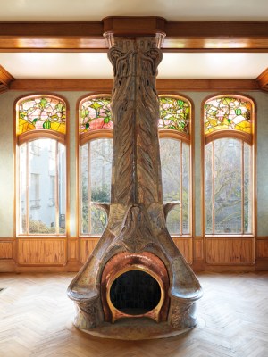 The dining room of the Villa Majorelle, designed by Henri Sauvage (1873–1932) and built in 1901–02, with a fireplace designed by Alexandre Bigot (1862–1927) and stained glass by Jacques Gruber (1870–1936). Photo: S. Levaillant; © musée d’École de Nancy