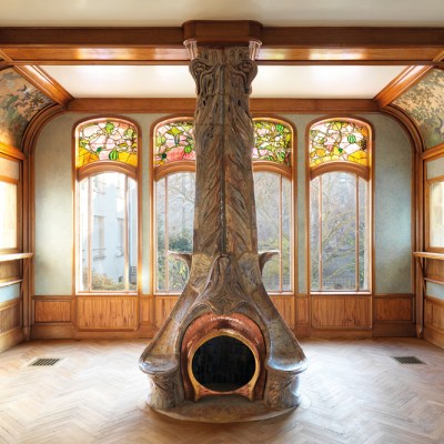 The dining room of the Villa Majorelle, designed by Henri Sauvage (1873–1932) and built in 1901–02, with a fireplace designed by Alexandre Bigot (1862–1927) and stained glass by Jacques Gruber (1870–1936). Photo: S. Levaillant; © musée d’École de Nancy