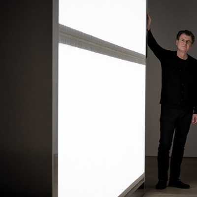 Alfredo Jaar photographed next to his installation ‘The Sound of Silence’ (2006) at Yorkshire Sculpture Park in October 2017. Photo by Jonty Wilde