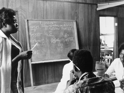 A volunteer mathematics teacher with students at Tufts, Mound Bayou, Mississippi (1968), Doris Derby.