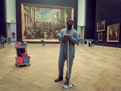 Omar Sy as Assane Diop in 'Lupin', with Veronese's 'Wedding Feast at Cana' in the background.