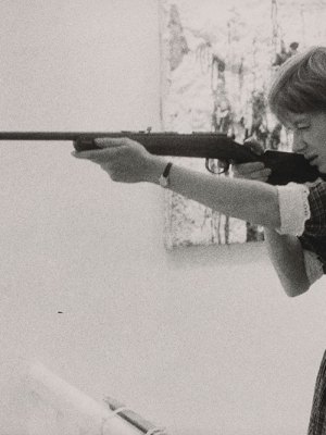 Niki de Saint-Phalle taking aim at her Feu à Volonté at Galerie J in Paris, in 1961.