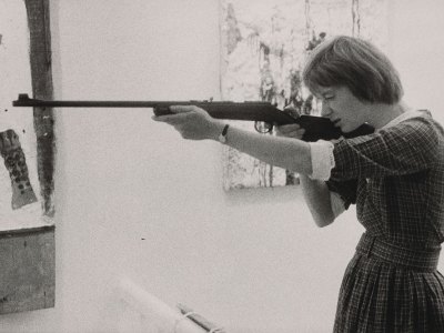 Niki de Saint-Phalle taking aim at her Feu à Volonté at Galerie J in Paris, in 1961.