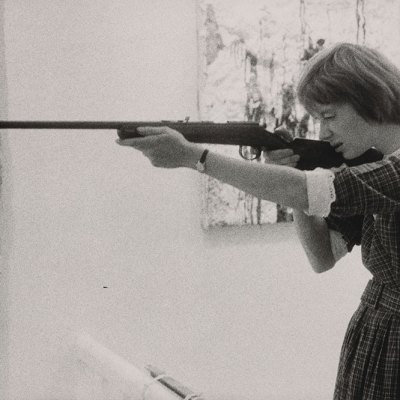 Niki de Saint-Phalle taking aim at her Feu à Volonté at Galerie J in Paris, in 1961.