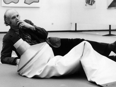 Pop artist Claes Oldenburg with one of his works, an outsize tube of toothpaste on display in the Dusseldorf Kunsthalle, West Germany.