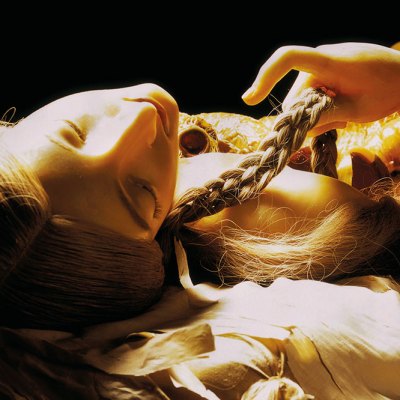 wax figurine of a girl lying down