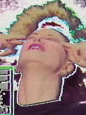 film still of glitching screen with a woman pressing her fingers to her temples