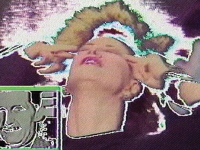 film still of glitching screen with a woman pressing her fingers to her temples